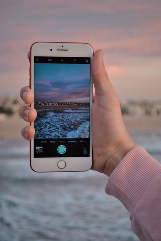 使用带有海滨墙纸的产品红色iPhone 7的人