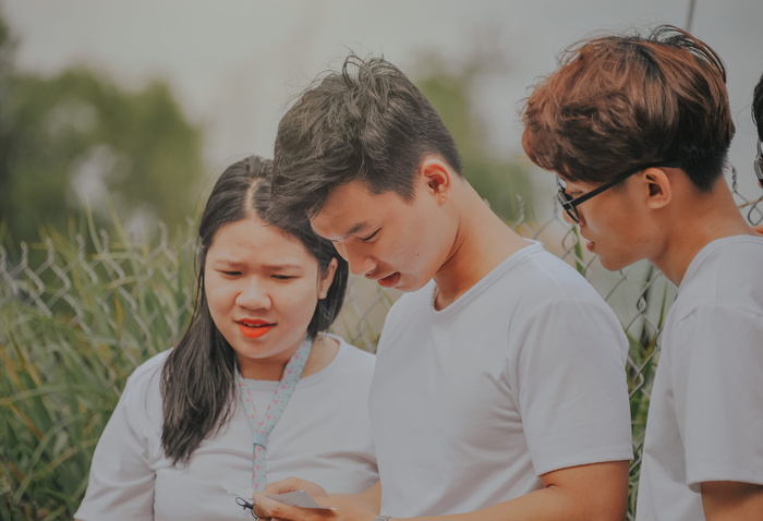 一个穿着白色T恤的男人看着他的手机