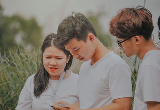 一个穿着白色T恤的男人看着他的手机