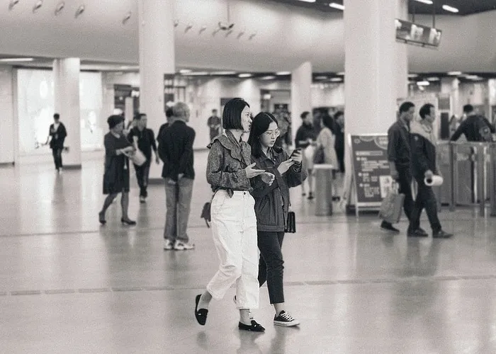 两个女人拿着手机走路