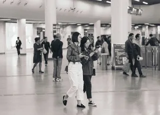 两个女人拿着手机走路