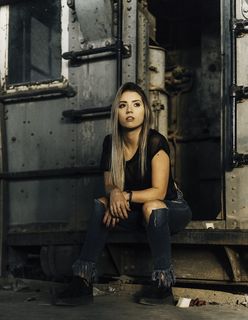 一名女子坐在金属板上的照片