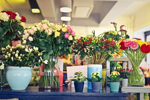 花店展示区,白天桌子上摆着各种花卉 花店展示区,白天桌子上摆着各种花卉