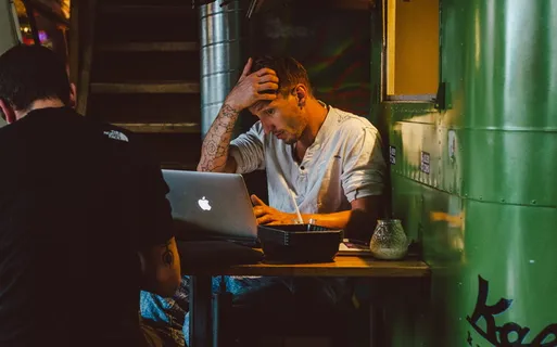 一名男子在银色MacBook前搔头 一名男子在银色MacBook前搔头
