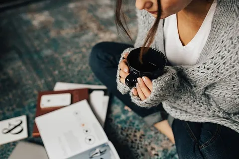 女人一边喝茶一边在地上看杂志 女人一边喝茶一边在地上看杂志