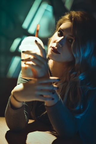 举着塑料杯的女人的照片