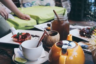 橙色陶瓷茶壶旁的白色陶瓷杯