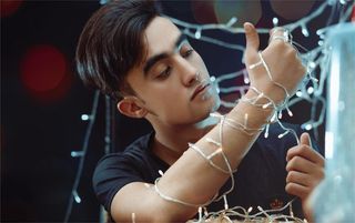 手持白色细绳灯的男子