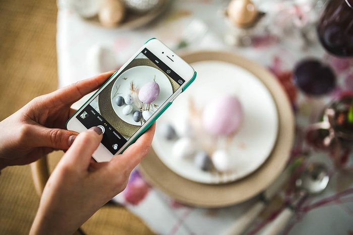 复活节桌上有可爱的粉红色装饰、鲜花、柳絮和鸡蛋