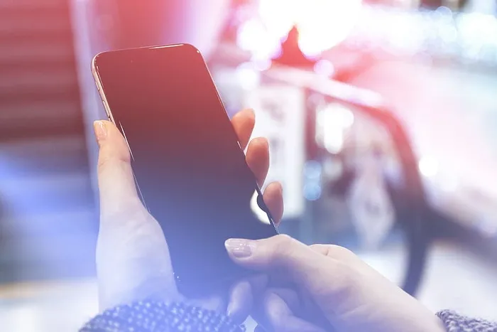 现代智能手机在女性手中。用指纹解锁手机