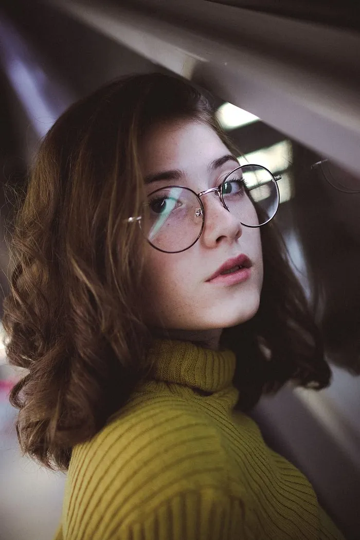 戴眼镜的女人穿着黄色毛衣的照片