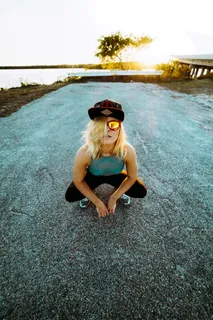 日落时，一个穿蓝色无袖衣服的女人在拍照