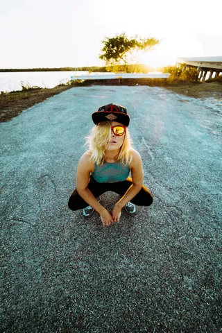 日落时，一个穿蓝色无袖衣服的女人在拍照