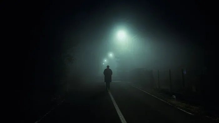 一名男子开着路灯走在布莱克托普路上