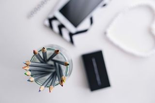 黑白笔记本和带有各种物品的白色智能手机