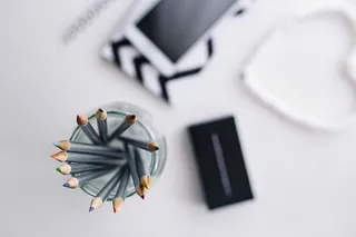 黑白笔记本和带有各种物品的白色智能手机