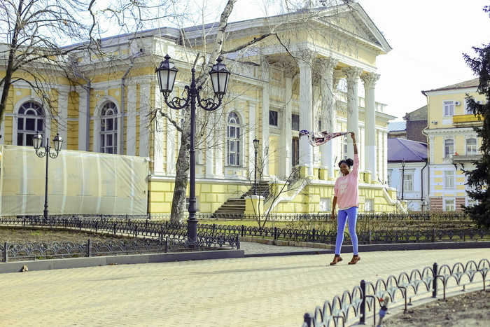 街头穿着粉色长袖衬衫和蓝色裤子的女孩