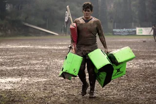 一名浑身泥泞的男子手持皮革训练垫