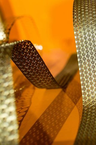 橙色背景上弯曲的金色金属