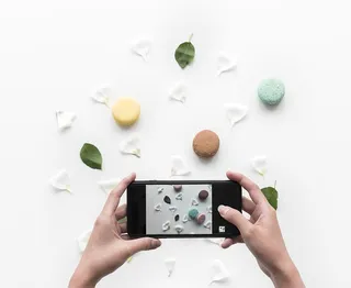 通过智能手机拍摄食物和花瓣的人