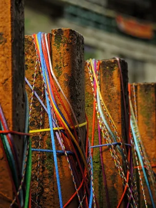 棕色金属围栏配蓝红色和黄色橡皮筋选择性聚焦照片