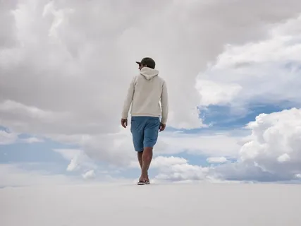 白天,在白云和蓝天下的白色表面上行走的人 白天,在白云和蓝天下的白色表面上行走的人