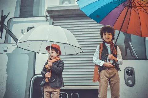 两个孩子微笑着拿着雨伞 两个孩子微笑着拿着雨伞