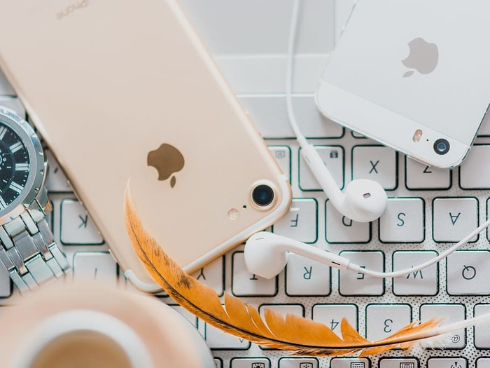 金色iPhone 7配白色苹果耳机和银色iPhone 5s