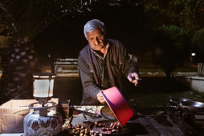 商人，老人，小贩，栗子，卖栗子，板凳，星期天，晚上