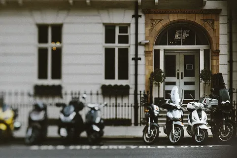 八辆各式摩托车停在水泥地面上