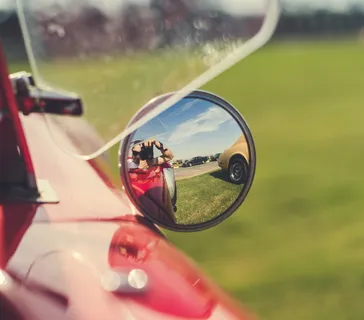 在车侧后视镜上拍照的人的选择性聚焦摄影