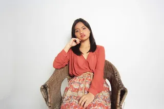 坐在棕色柳条扶手椅上的女人