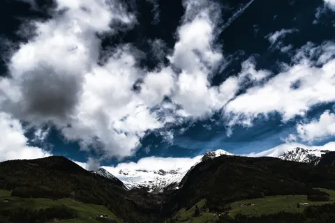 照片:天空下群山附近的绿地 照片:天空下群山附近的绿地