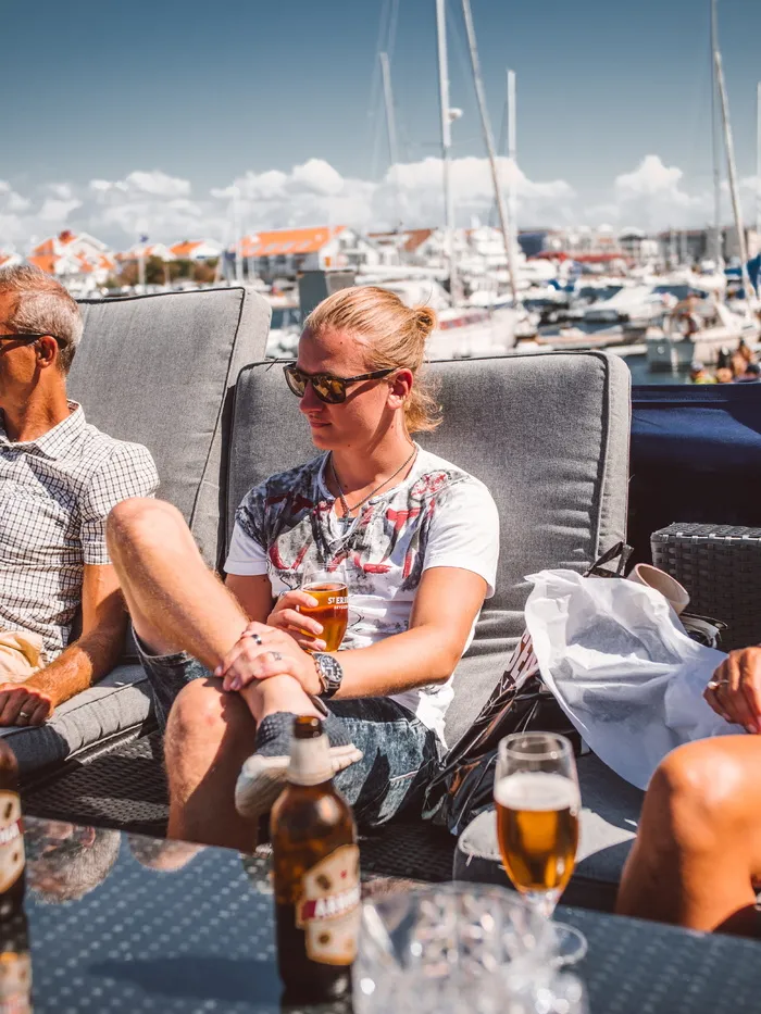 坐在灰色软垫日光躺椅上的男子