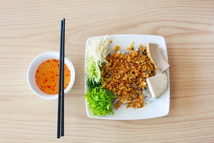 用酱汁和筷子放在碗旁的盘子里的食物