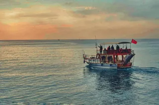 白天，棕色和白色的船在海洋*航行