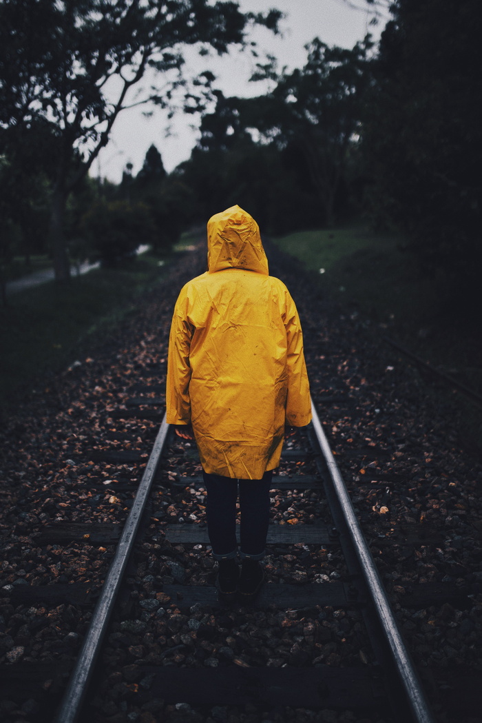 铁路上穿着雨衣的人的照片