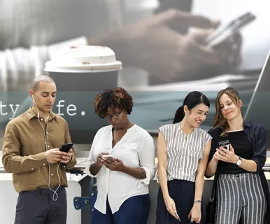 三个女人和一个男人在看智能手机