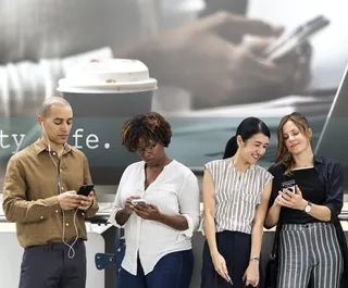 三个女人和一个男人在看智能手机