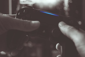 男子手持索尼Ps4无线控制器的黑白照片