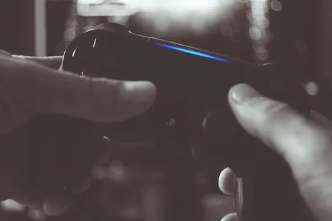 男子手持索尼Ps4无线控制器的黑白照片 男子手持索尼Ps4无线控制器的黑白照片