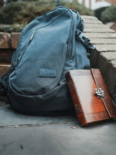 混凝土板上的棕色皮革公文包和灰色手提包