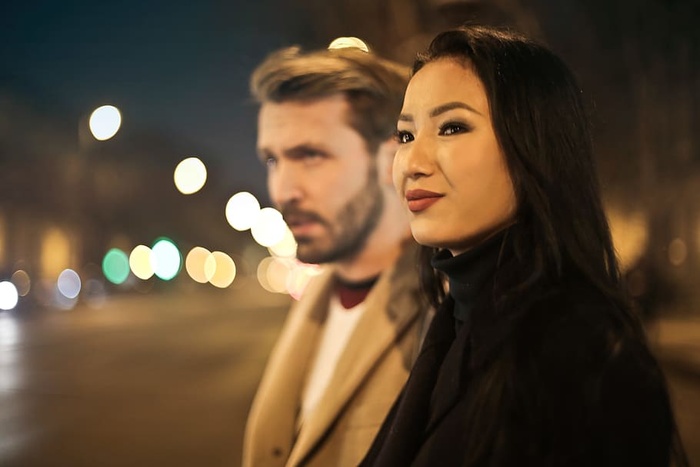 一对年轻的成年夫妇晚上外出时在路边等候