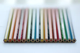 白色面板上堆叠的彩色铅笔