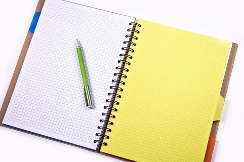白色绘图笔记本上的绿色点击笔 白色绘图笔记本上的绿色点击笔