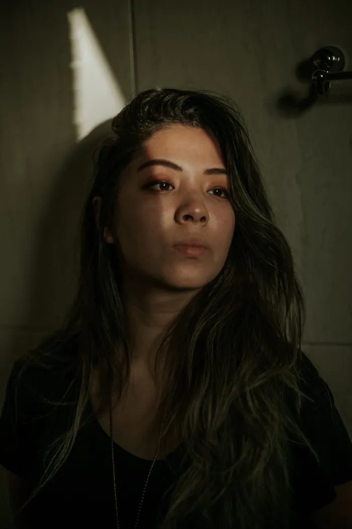 棕色木柜前身穿黑色圆领衬衫的女人