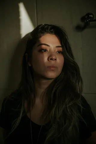 棕色木柜前身穿黑色圆领衬衫的女人