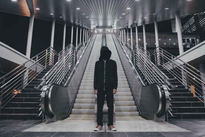 身穿黑色拉链连帽衫的男子站在楼梯附近