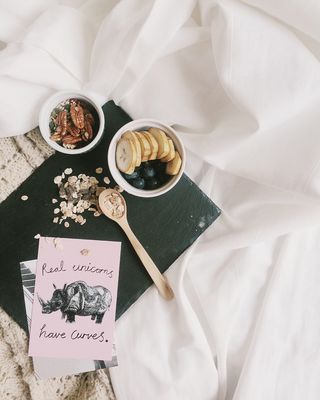 白色水果切片碗旁棕色木勺平放照片