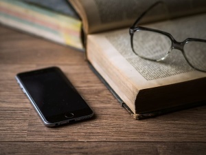 将灰色Iphone 6放在书旁边的棕色桌子上